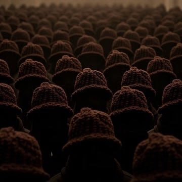 Rows of identical figures in the same beanie